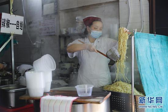 4月22日，武漢市糧道街的家陽“趙師傅”天天紅油熱干面店廚師在制作熱干面。新華社記者 沈伯韓 攝