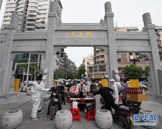  4月16日，進(jìn)出武漢漢正街步行街的人員在掃描健康碼。新華社記者 王毓國 攝