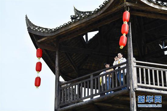  游客在重慶市武隆區(qū)黃鶯鄉(xiāng)復(fù)興村的觀景樓上欣賞田園景色（2019年3月28日攝）。 新華社記者 劉潺 攝